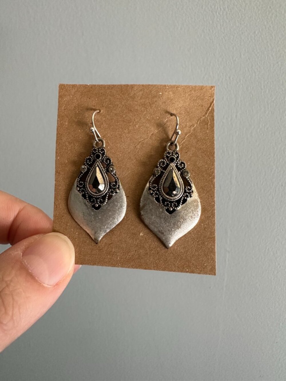 Metal teardrop dangle earrings with black gem accents